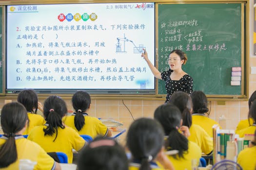 A teacher instructs students in a chemistry class, using a digital board for interactive learning.